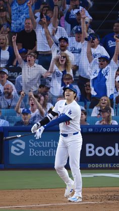 a baseball player holding a bat on top of a field in front of a crowd