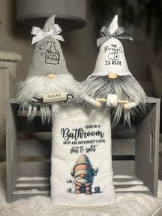 two towels with funny hats on them sitting on a table next to a lamp shade