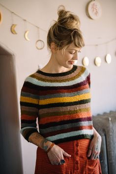 a woman wearing an orange skirt and striped sweater