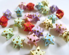 many different colored origami stars on a white surface