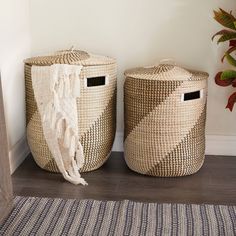 two woven baskets sitting next to each other on a rug in front of a door