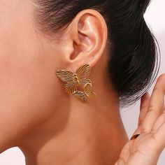 These Large Gold Butterfly Earrings make a bold statement with their stunning design. Perfect for adding a touch of elegance and sophistication to any outfit. These earrings will surely catch attention and elevate any look. DETAILS & SIZE Sold as a pair Finish: 18K gold plate Material: Stainless Steel Measurements: 1.6"x1.2" Weight: 12.6 grams Comes with friction earring backs Waterproof, tarnish-resistant, and nickel free Shop Earrings to curate your ear stack! Yellow Gold Plated Bridal Earrings, Modern Bridal Earrings For Parties, Luxury Clip-on Earrings With Plating, Elegant Butterfly Earrings For Formal Occasions, Elegant Gold Butterfly Earrings, Elegant Gold Butterfly-shaped Earrings, Elegant Single Butterfly Earring, Gold Plated Single Bridal Earring, Gold Butterfly Earrings For Formal Occasions