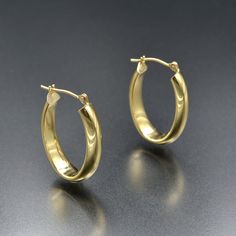 A lovely, thick pair of golden hoop earrings, fashioned in 14 karat gold. These vintage earrings are a great size, with an elongated oval shape. The hollow design makes them incredibly lightweight, while being very solid in their construction - perfect for everyday wear. The earrings secure by a hinged, slightly curved ear-wire that fastens in a U-shaped catch.   More details: 17.4mm front to back, 12.7mm front to back (inside of hoop,) 24.5mm top to bottom, 4.9mm thick Excellent condition 14k (stamped) 1.7 grams Classic Oval Earrings For Everyday, Hallmarked Oval 14k Gold Huggie Earrings, Classic 14k Huggie Hoop Earrings, Classic Gold Rounded Earrings, Classic 14k Hoop Earrings For Anniversary, 14k Gold Oval Huggie Earrings Hallmarked, Formal Minimalist Oval Huggie Earrings, Classic Oval Hoop Earrings As Gift, Formal Oval Huggie Earrings With Polished Finish