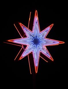 a blue and red lighted star in the dark