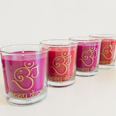 three votive candles with gold lettering on them