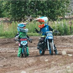 two children on dirt bikes in the mud