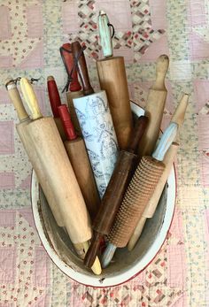 a bowl filled with lots of different types of hairbrushes and combs on top of a table