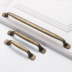 three antique style handles on a white door