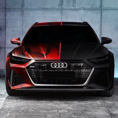 the front end of an audi car with red and black stripes on it's hood