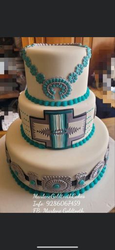 a three tiered cake with blue and silver decorations