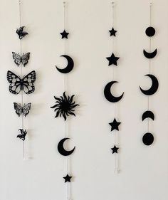 a group of black and white wall hangings with butterflies, sun, moon and stars