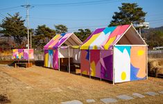 colorful tents are lined up on the dirt