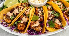 chicken tacos with cole slaw and guacamole on a white plate