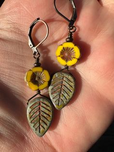 Czech glass yellow flowers with green leaves and a Picasso finish. Antique copper metals and lever back ear wires. 2 inches long. Green Botanical Drop Earrings Jewelry, Yellow Czech Glass Dangle Earrings, Yellow Bohemian Nickel-free Flower Earrings, Yellow Flower Drop Earrings With Ear Wire, Botanical Green Jewelry With Ear Wire, Nature-inspired Green Dangle Flower Earrings, Nickel-free Yellow Czech Glass Earrings, Nickel Free Yellow Czech Glass Earrings, Adjustable Nickel-free Yellow Flower Earrings