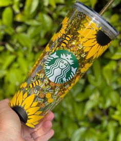 the starbucks cup is decorated with sunflowers and gold confetti flakes