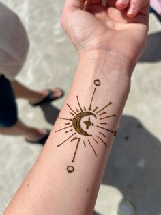 a person's arm with a sun and moon tattoo on it