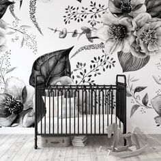 a baby crib in front of a floral wall mural