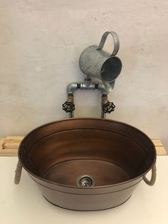 a large metal bowl sitting on top of a counter next to a faucet