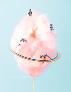 there are birds flying in the sky and on top of a cotton candy lollipop