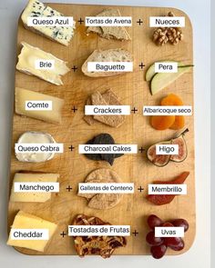 a wooden cutting board topped with different types of cheeses and crackers on top of it