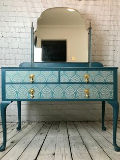 a blue dresser with an ornate design on it and a mirror over the top that says coco & clementine