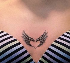 a woman's chest with an angel wing tattoo on her left side ribcage