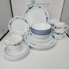 a white table topped with plates and cups