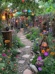 a garden filled with lots of flowers next to a lush green forest covered in hanging lanterns