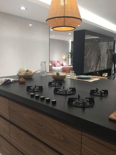 a kitchen with a black counter top next to a living room and dining room area