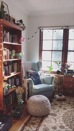 a living room filled with lots of furniture and bookshelves next to a window