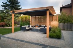 an outdoor living area with couches, tables and a pergolated covered patio