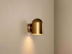 a wall light that is on the side of a wall next to a white wall