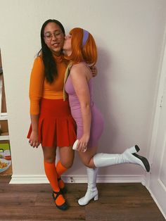 two women dressed in costumes kissing each other