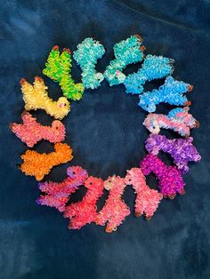 several small teddy bears are arranged in a circle on a blue background with the colors of the rainbow