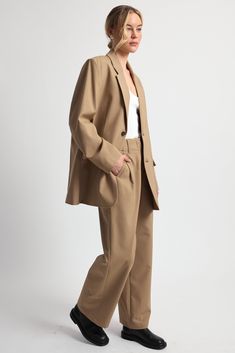 Our Oversized Double Button Blazer combines classic tailoring with contemporary flair. It features a timeless double button closure. Pair it with our Adjustable Waist Trousers for an effortless look. Timeless Fall Workwear Pantsuit, Timeless Fall Pantsuit For Work, Classic Pantsuit With Welt Pockets And Straight Hem, Tailored Button Closure Pantsuit For Business Casual, Chic Business Casual Suits With Button Cuffs, Classic Fall Pantsuit For Office Wear, Modern Suits With Button Closure, Modern Blazer With Buttons For Work, Modern Blazer With Button Closure For Work