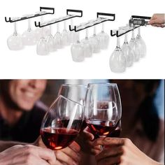 there are many wine glasses being held up by the bar handle on each glass and one is filled with red wine