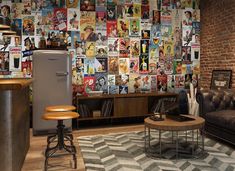 a living room filled with furniture next to a brick wall covered in comic book covers