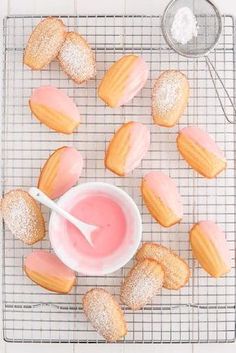 powdered donuts on a cooling rack with pink icing in a small bowl