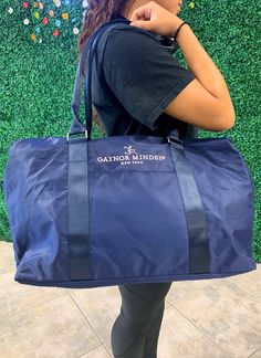 a woman carrying a large blue duffel bag