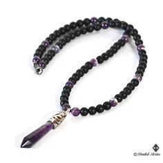 The centerpiece of this long gemstone men's necklace is an Amethyst healing point pendant. The combination of black matte onyx and shiny purple striped amethyst beads creates balanced, manly and sophisticated look. This piece is perfect for making a statement effortlessly and stylishly. This necklace is strung on a beaded wire and finished off with a lobster claw clasp. You can select the necklace length from the drop-down menu on the right. The pendant measures approximately 2.36 inches long (6 Black Amethyst Gemstone Beads Jewelry, Black Amethyst Beads Jewelry 8mm, Black Amethyst 8mm Bead Jewelry, Black Amethyst Gemstone Beads Necklace, Black Gemstone Crystal Necklace For Spiritual Use, Black Spiritual Crystal Necklace With Gemstone, Spiritual Black Crystal Necklace With Gemstone, Spiritual Black Gemstone Crystal Necklace, Boho Men