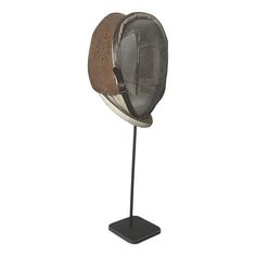 a metal hat on a stand with a mesh covering it's face and head