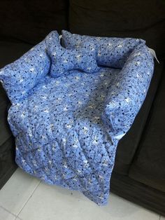 a blue crocheted blanket sitting on top of a black couch