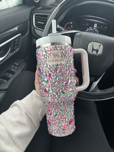 a person holding a cup in their car