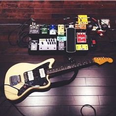 an electric guitar is laying on the floor next to other musical instruments and equipment that are plugged in