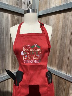 a red apron that says, we are beginning to eat like christmas on the front