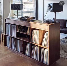 an old record player sits on top of a bookcase in front of a window