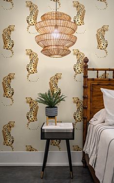 a leopard print wallpaper in a bedroom next to a night stand with a plant on it