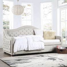 a living room with a couch, rug and windows