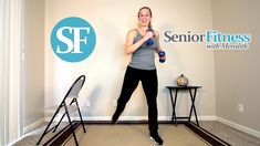 a woman standing in front of a wall holding a blue bottle and dumbbells