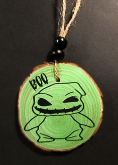 a green wooden ornament with an image of a baby yoda on it